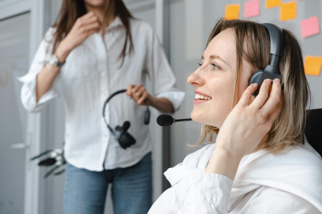 Kaukasische Frau, die als Callcenter-Agentin arbeitet und telefonisch mit Kunden kommuniziert.