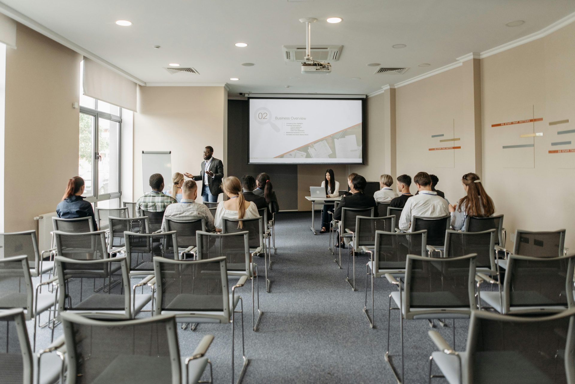 Eine Gruppe nimmt an einer Geschäftspräsentation in einem modernen Konferenzraum mit Projektor teil.